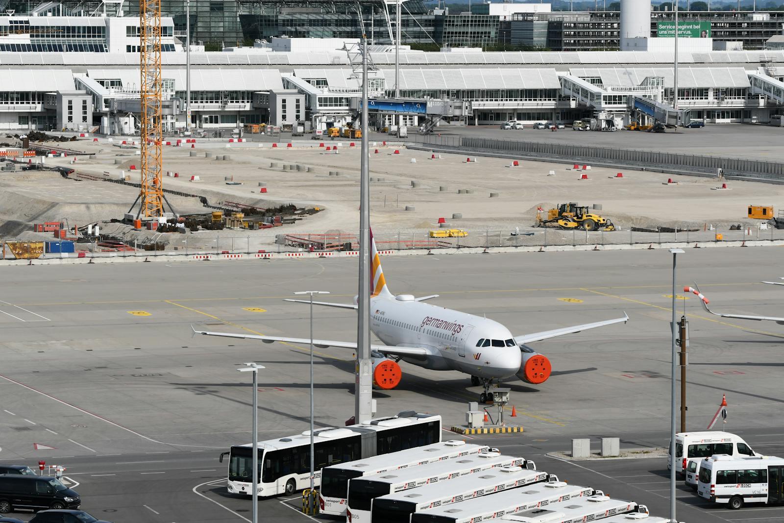 Airport apron with an Airbus aircraft beside an active construction zone.