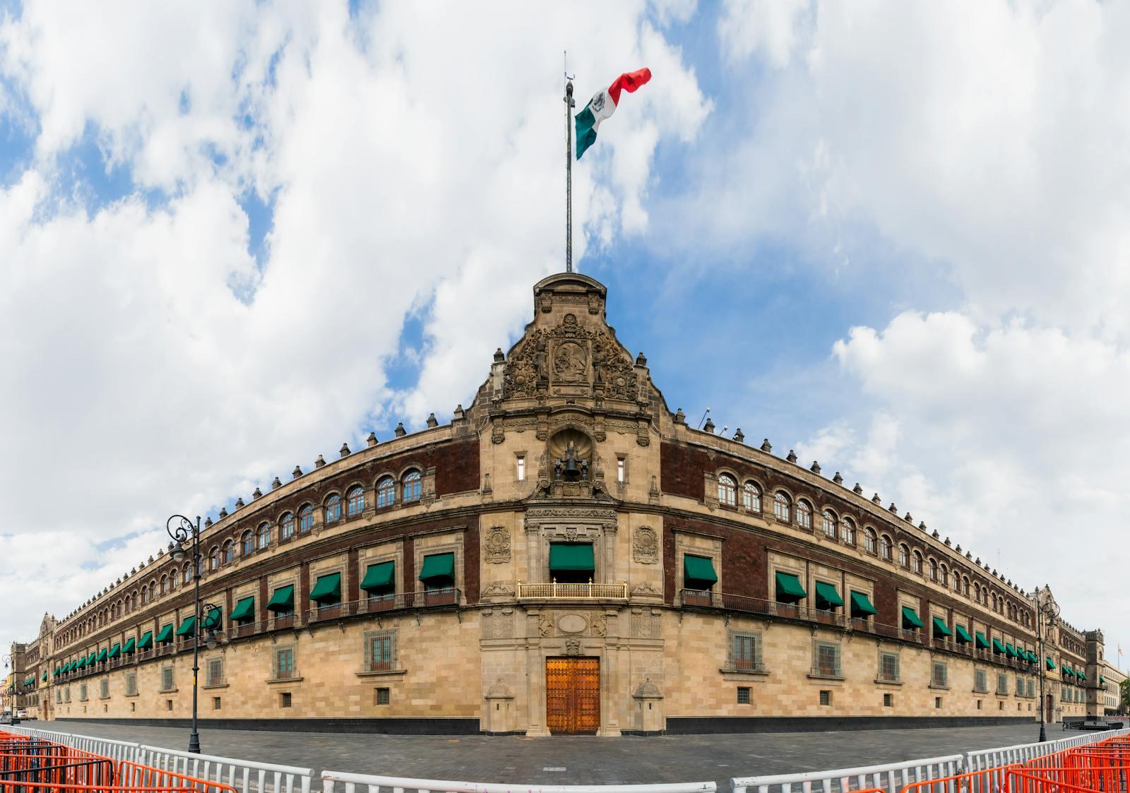 National Palace of Mexico in Mexico City beneath a giant Mexican flag.