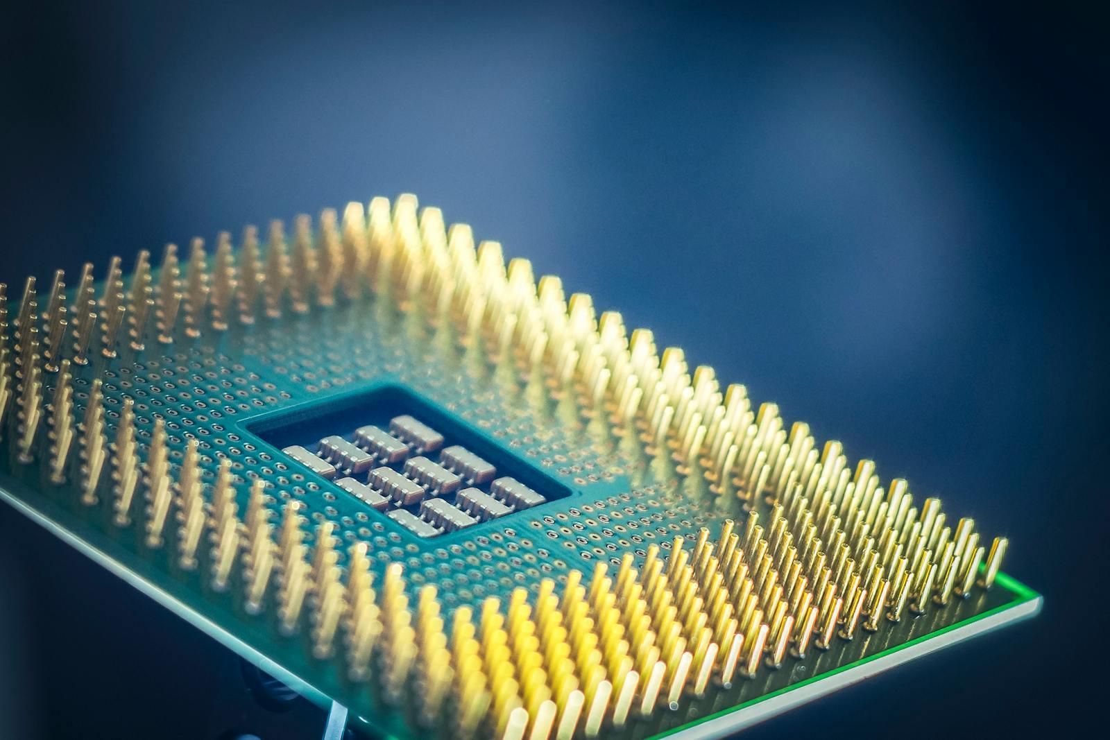 Macro view of a CPU chip with gold pins against a blue background.