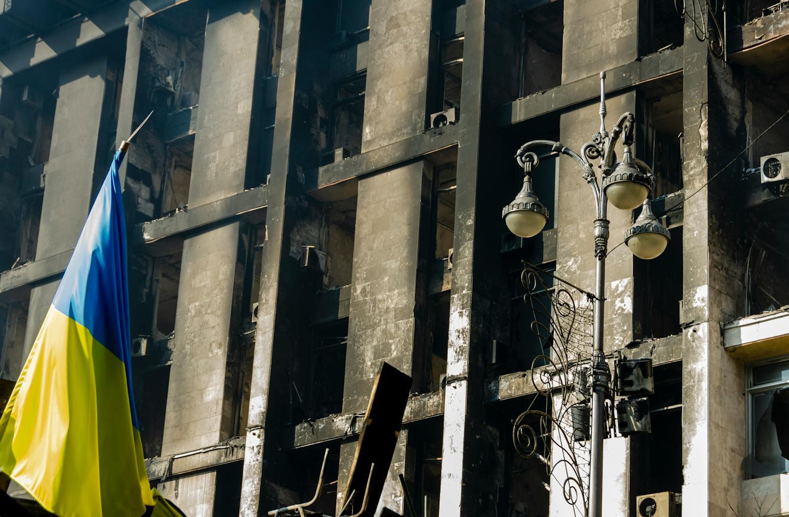 A damaged residential building in Kyiv flying a Ukrainian flag, more than three years into Russia's full-scale war.