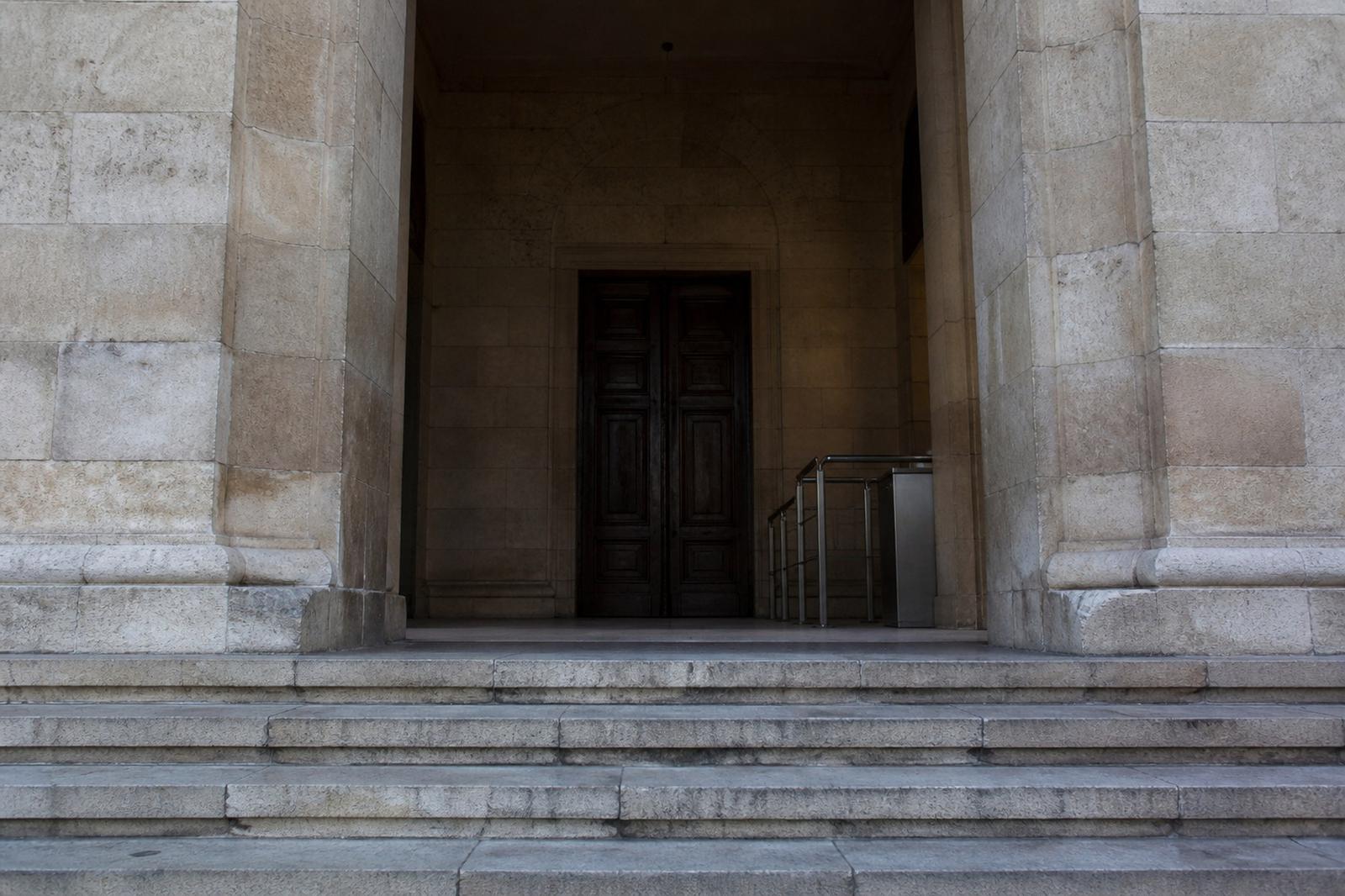 Des marches de pierre désertes devant une représentation illustrative du palais de justice de Damas.